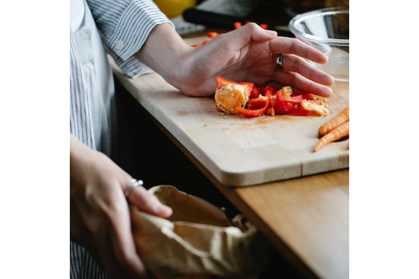 Person putting food scraps in the bin.