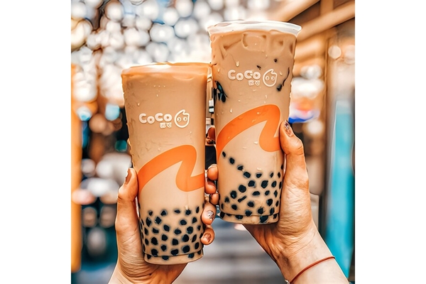 Image Two hands holding glasses of bubble tea.