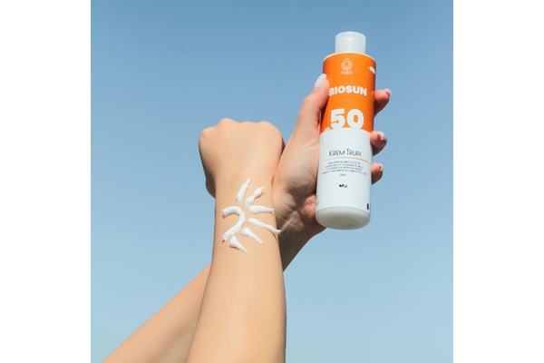 Image An arm with sunscreen on it in the shape of a sun.