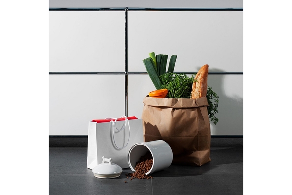 A can of beans is placed next to a bag of bread and vegetable on the floor.