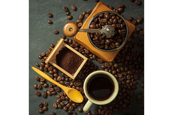 On the table, there are coffee beans and a cup of coffee.