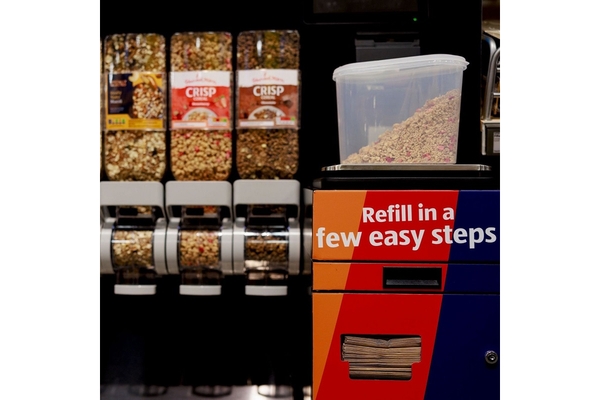 Reusable vessels are located at a refill station next to a sign saying "Refill in a few steps".