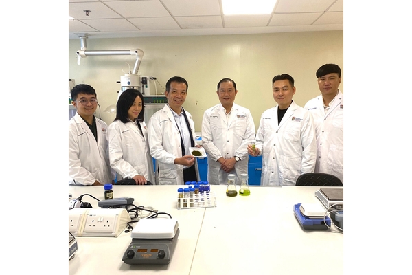 Image A team of scientists in white lab coats standing in a laboratory.