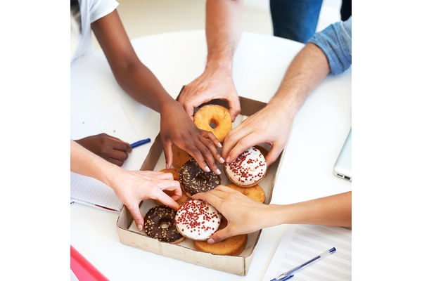 Hands taking donuts.
