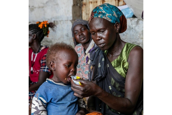 South Sudan. Woman feeding her kid.