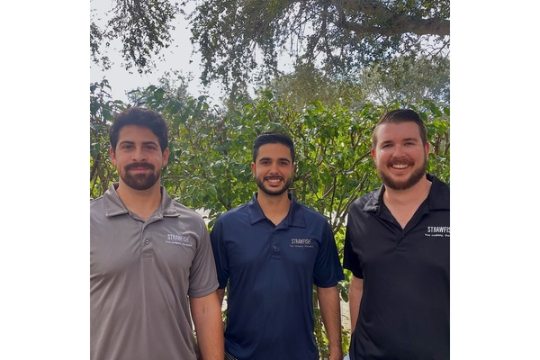 Three men standing in garden.