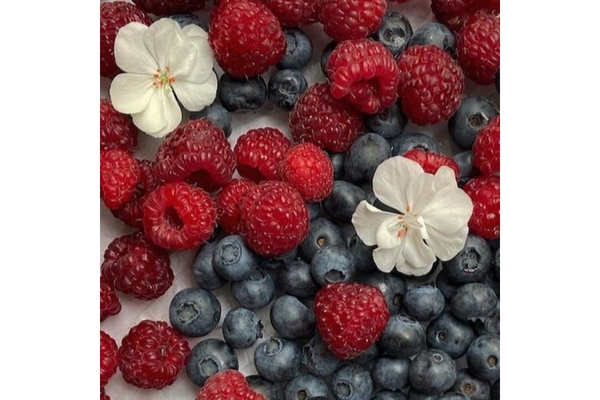 Image Two white flowers raspberries and blueberries.