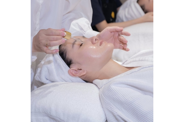 Image A woman getting a serum put on her face.
