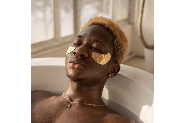 Image A man sitting in a bath with eye masks on.