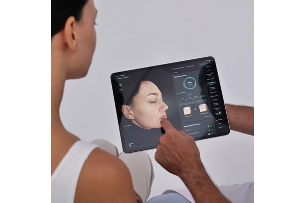 dermatologist shows a tablet to woman with analysis of her skin