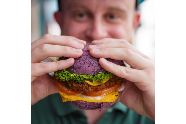 Image Man eating a plant-based burger.