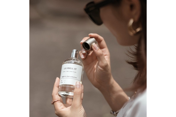 Image A woman opening a perfume bottle.