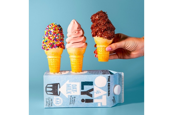 Image A tetra pak carton of Oatly drink and a hand holding an ice cream cone.