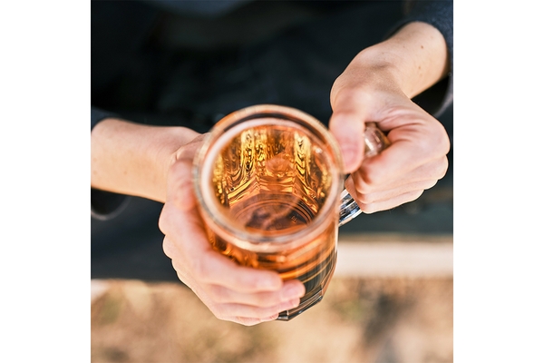 Image Hands holding beer glass.