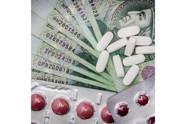 Image Different pills lying on top of dollar bills.