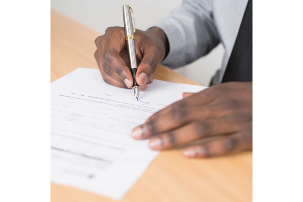 Two hands signing a document.