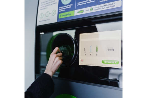 Image woman returns bottle reverse vending machine for Latvia DRS