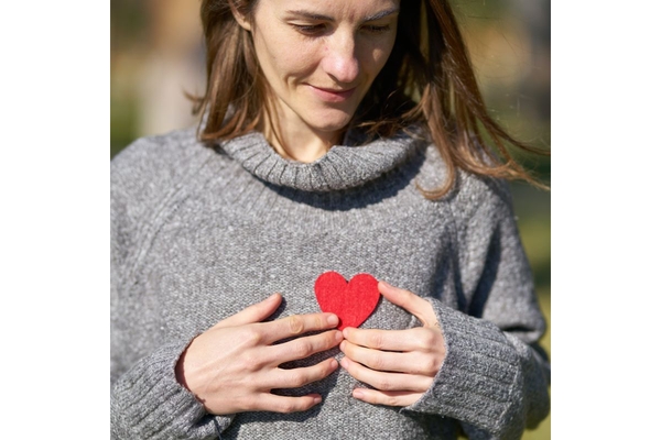 Image Women holds heart cut out on her chest