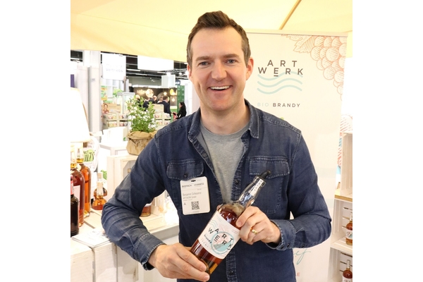 Benjamin Scheuerer, partner at Artwerk, holding a bottle of the brand's vacuum-processed brandy.