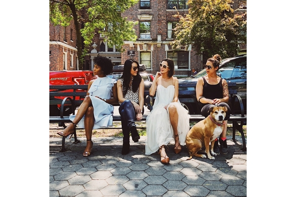 Women sitting on a bench in a park.