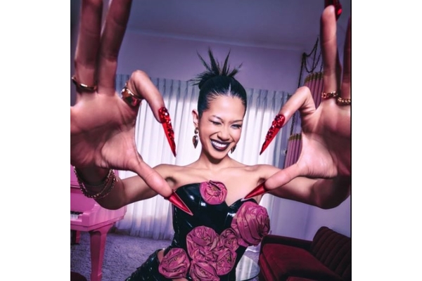 Woman wearing press on nails makes a heart sign
