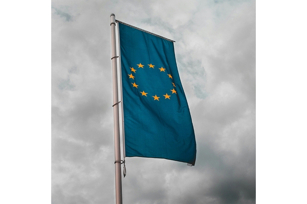Image EU flag against grey sky.