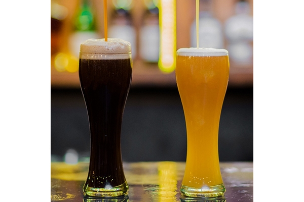 Image Two different kinds of beer is placed on a table.