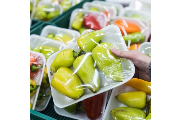 Holding fruit in plastic wrapping.