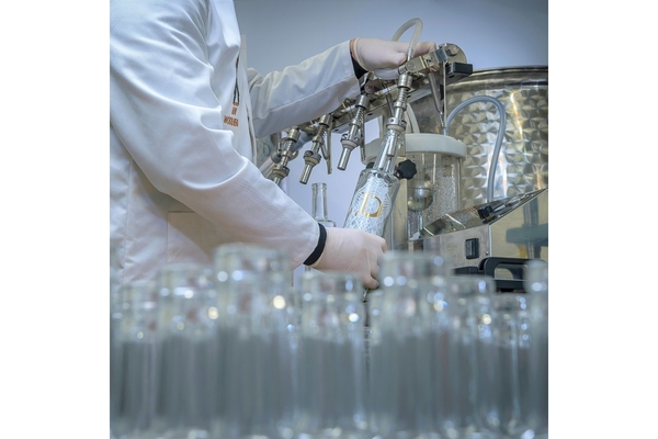 Image Filling glass bottles on machine.