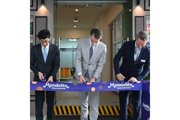 Three men in suits cutting a purple ribbon.