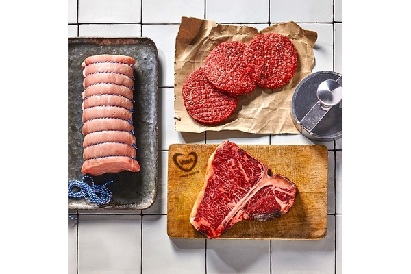 Image Cut pieces of meat kept on wooden boards.