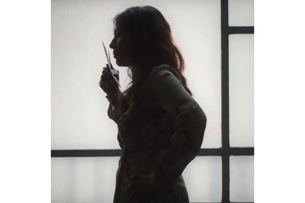 A woman smelling a piece of paper.