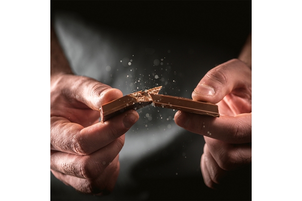 Image Hands breaking chocolate bar.