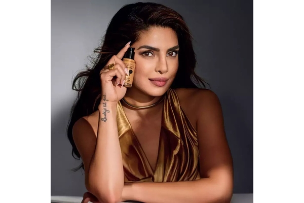 Image Priyanka Chopra holding a foundation from Max Factor up to her face.