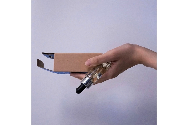 Holding perfume and packaging in hand.