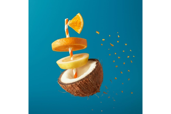 floating coconut split in half with slices of orange floating above it