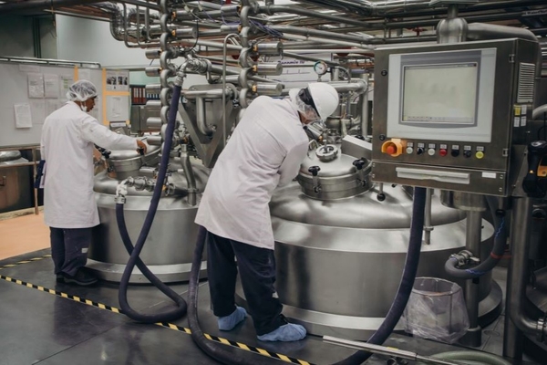 Two men checking fermentation machines.