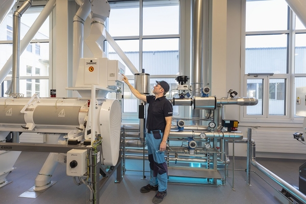 a man working in a food factory with milling equipment.
