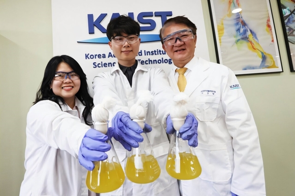 A group of people in lab coats holding flasks.