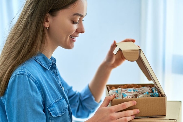 Image Woman unboxing parcel.