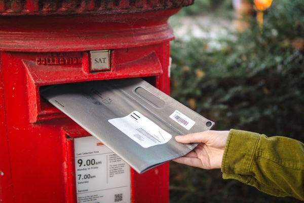 Placing mailer in mail box.