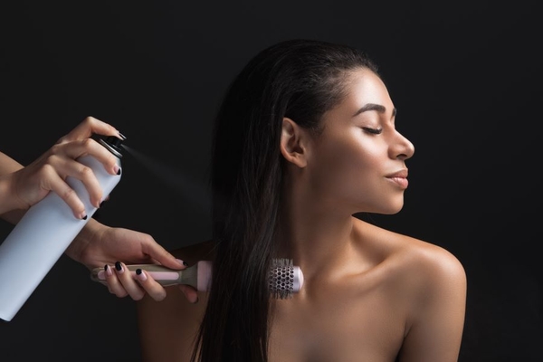 Image Girl-doing-styling-in-hair-salon with spray and brush