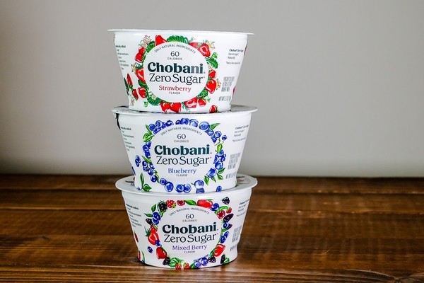 Chobani yogurts on wooden table with white background