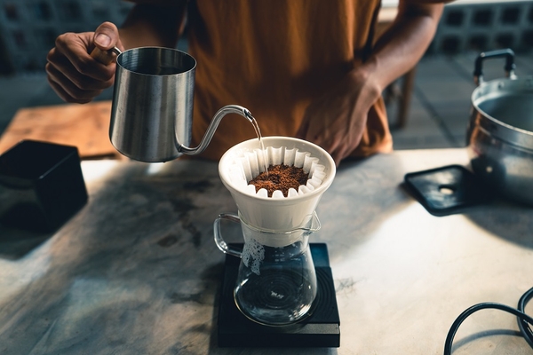 Drip coffee, barista pouring water on coffee ground with filter