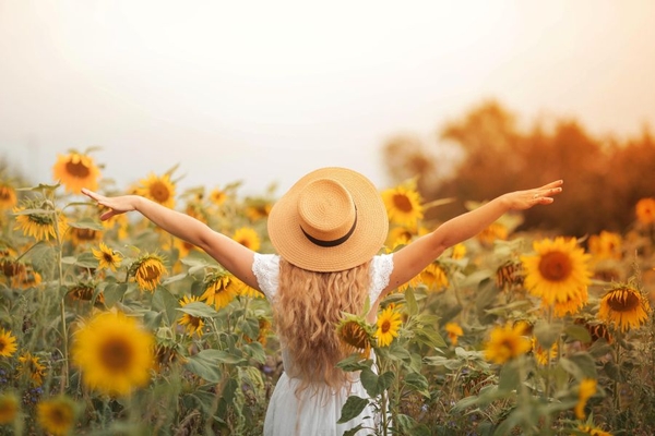 Image A woman standing in a field of sunflowers.