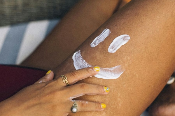 woman applying cream to leg in smiley face