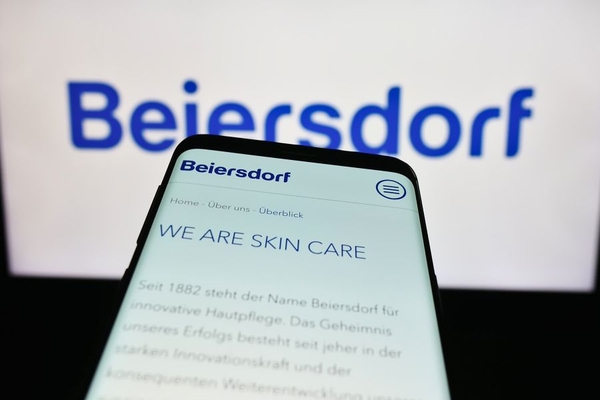 Beiersdorf in the background with a phone in front with "we are skin care" written on it.