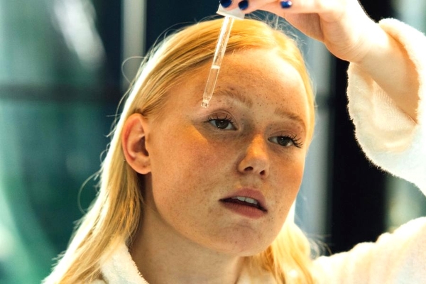 Image A woman putting a serum on her face.