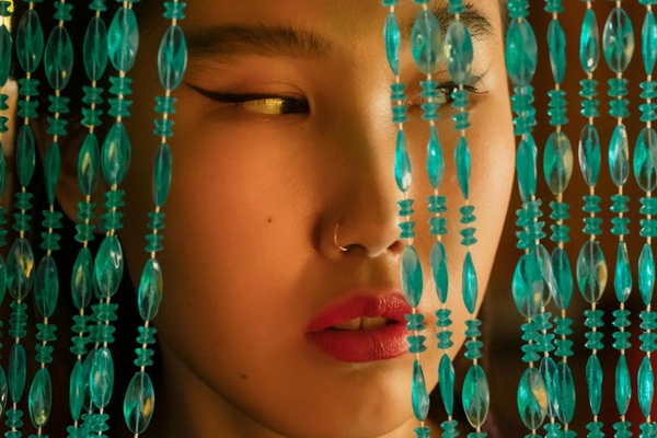 Image chinese woman looking through beaded curtains