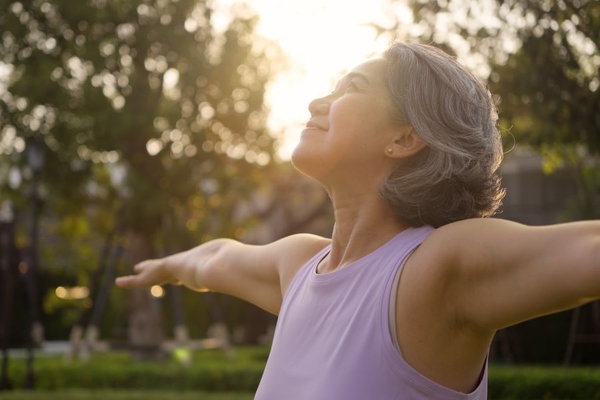 Image Asian woman middle aged happy doing yoga in park